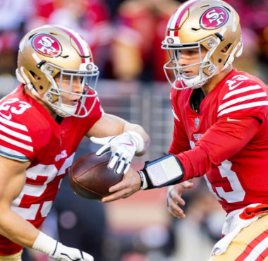 Christian McCaffrey, RB de los 49ers recibiendo el balón de Brock Purdy, QB de los 49ers