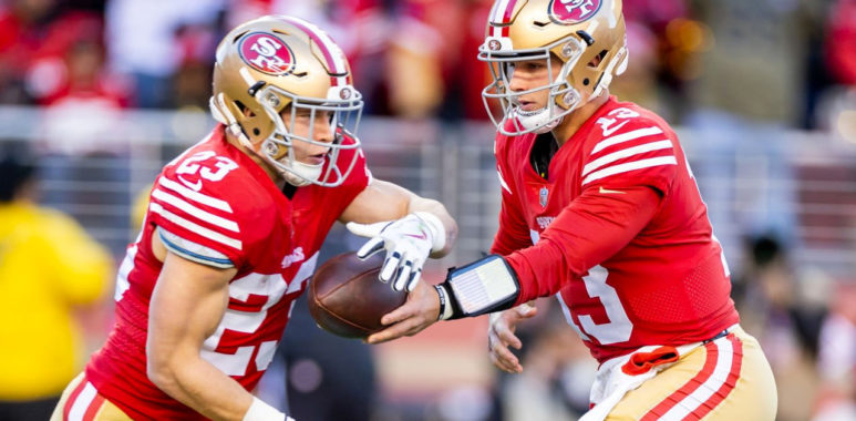 Christian McCaffrey, RB de los 49ers recibiendo el balón de Brock Purdy, QB de los 49ers